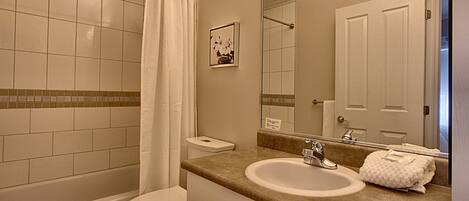 A bathroom with a toilet, sink, and shower.