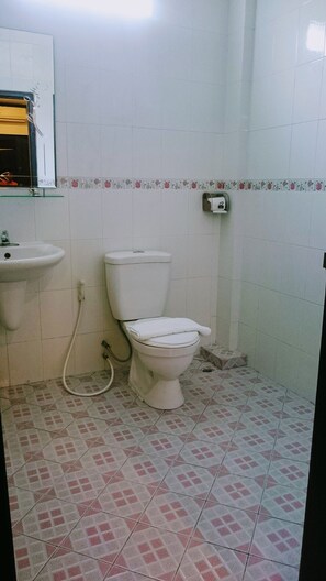 A small bathroom with a toilet, sink, and a mirror.
