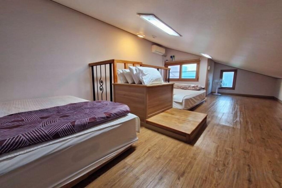 Un dormitorio con una cama, un aparador de madera y un ventanal.