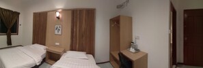 A hotel room with two single beds, a wooden wardrobe, a small table with a lamp, and a coat hanger. - Arung Hayat Semporna Resort (Semporna)