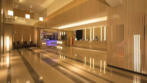 A modern hotel lobby with a reception desk, seating area, and a check-in counter. - HOTEL COZZI Zhongshan Kaohsiung (Kaohsiung)
