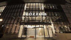 A modern building with a glass facade and illuminated signage reading "COZZI". - HOTEL COZZI Zhongshan Kaohsiung (Kaohsiung)