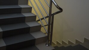 A staircase with a metal handrail and a modern design. - KL Hotel (Labuan)