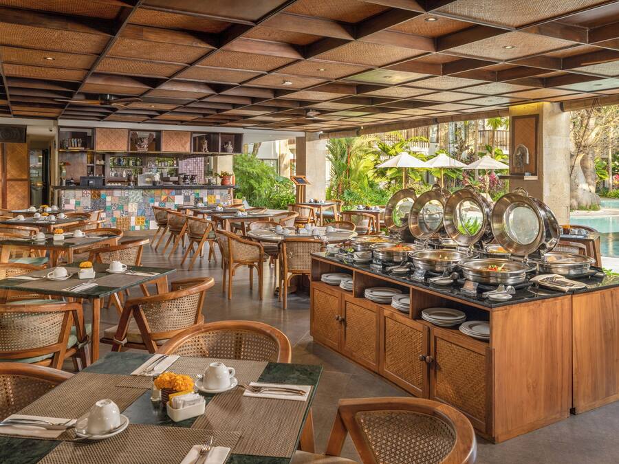 A restaurant with outdoor seating, a buffet area, and a pool view.