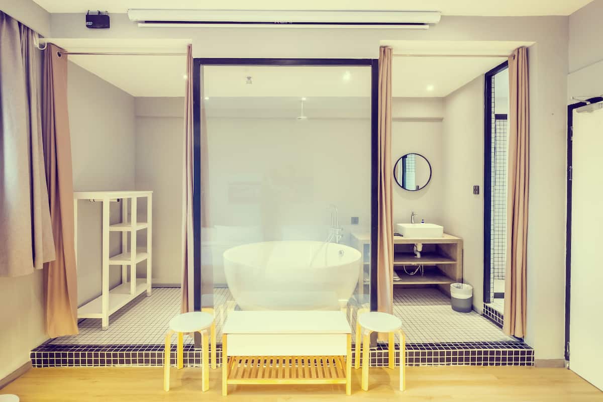 Un baño moderno con una bañera independiente, un lavamanos y un espejo.