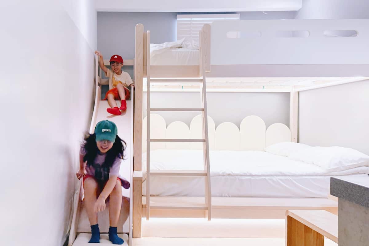 Habitación con literas, un escritorio pequeño y una ventana.