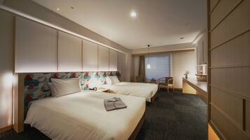 A hotel room with two beds, a desk, and a chair.