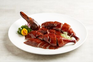 A plate of sliced duck with a decorative flower.