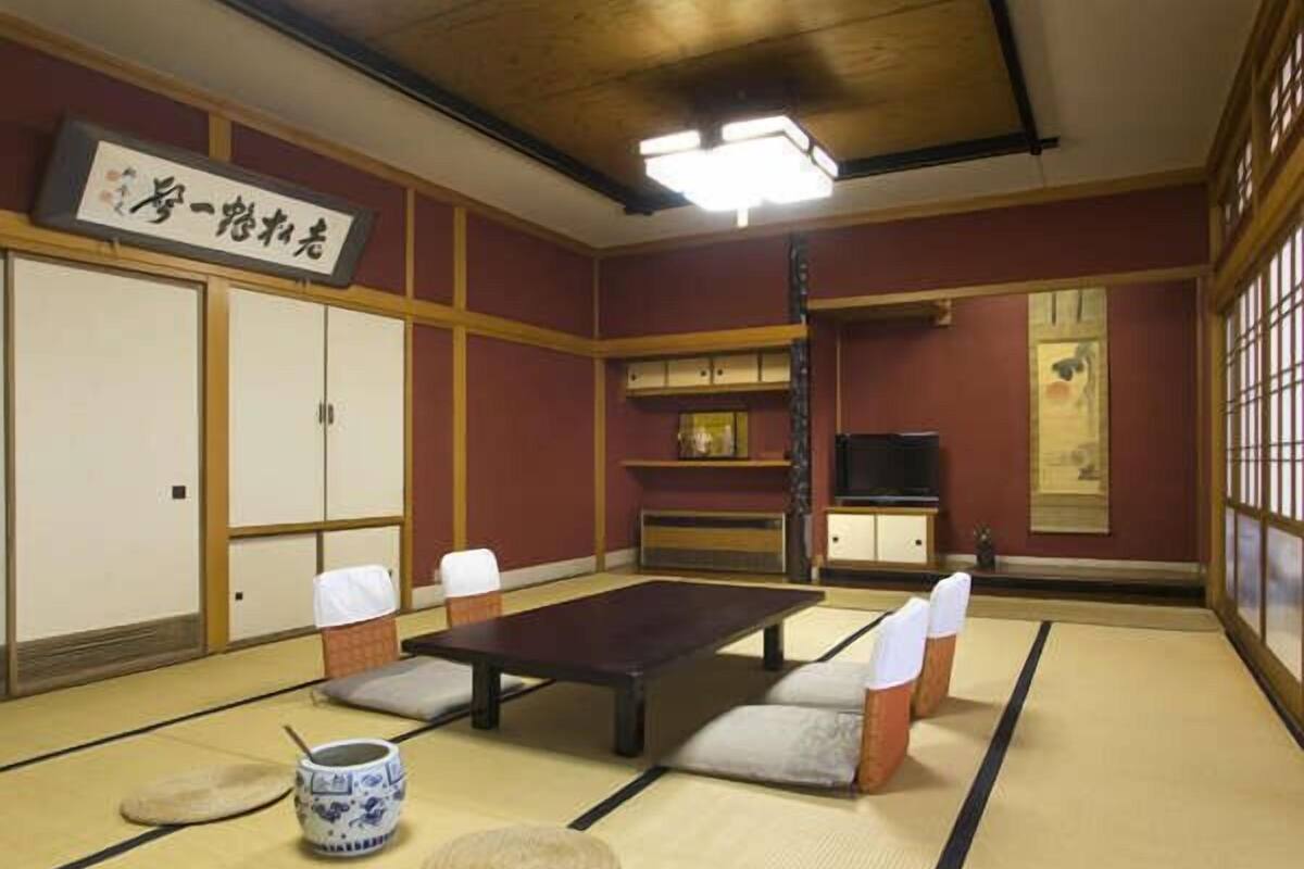 Une pièce de style japonais traditionnel, avec un sol recouvert de tatamis, une table basse et des coussins.