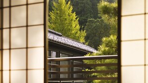Un bâtiment japonais traditionnel, avec un toit recouvert de tuiles et son reflet dans l’eau.