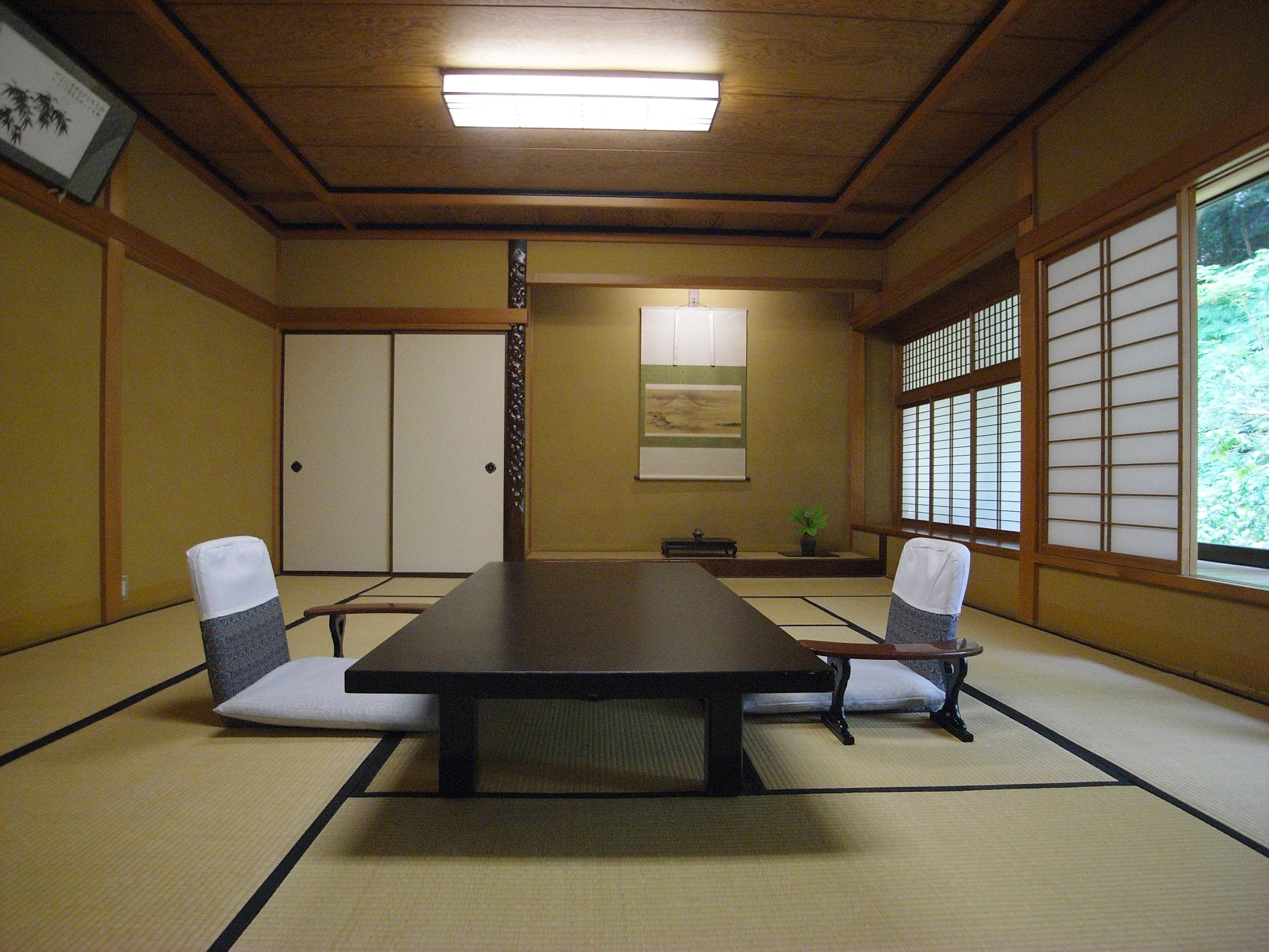 A traditional Japanese meeting room with tatami flooring, a low table, and shoji screens.