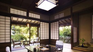 Une pièce de style japonais traditionnel, avec un sol recouvert de tatamis, une table basse et un service à thé.