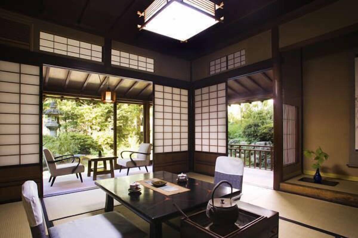 Une pièce de style japonais traditionnel, avec un sol recouvert de tatamis, une table basse et un service à thé.