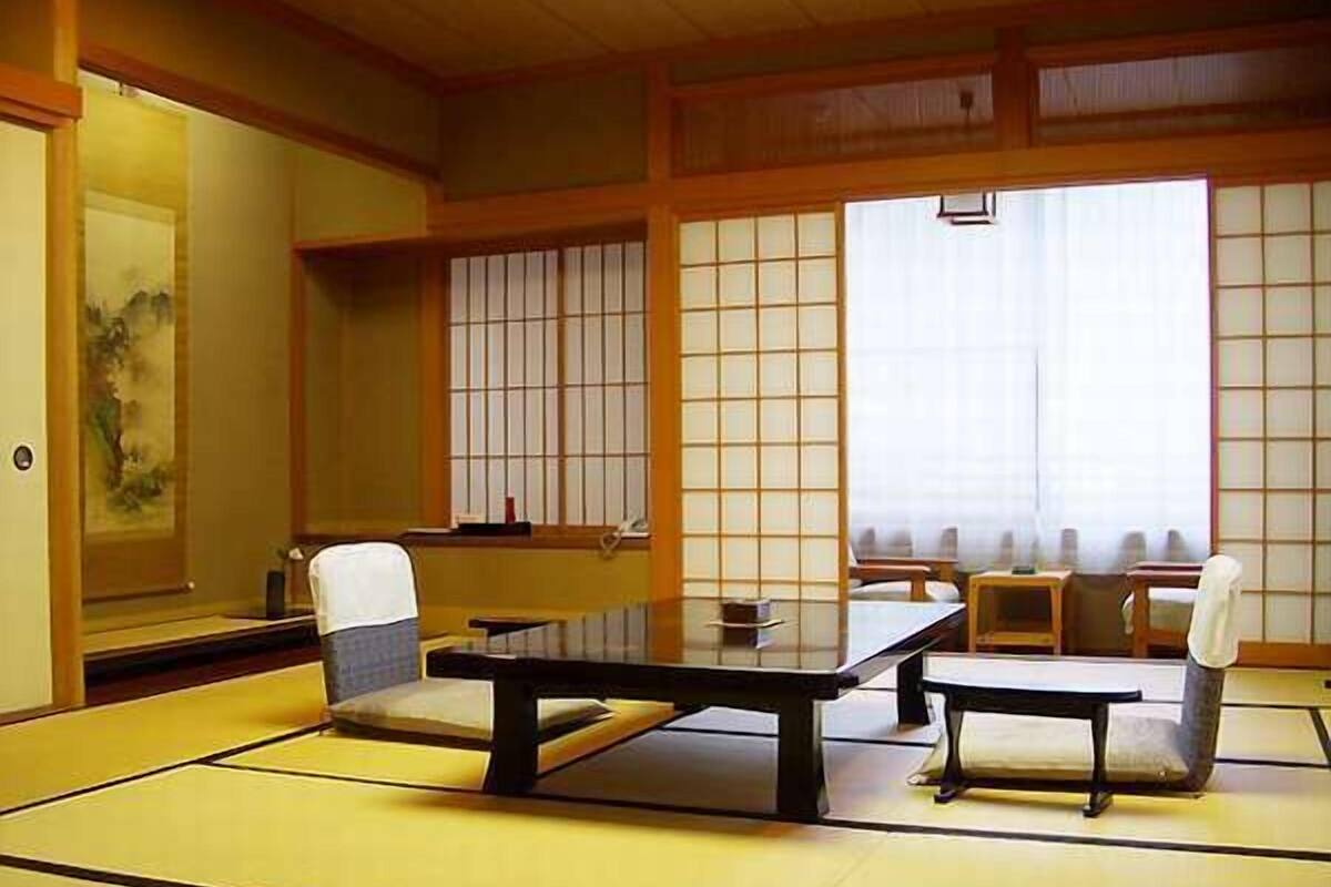 Une pièce de style japonais traditionnel, avec un sol recouvert de tatamis, une table basse et un canapé.