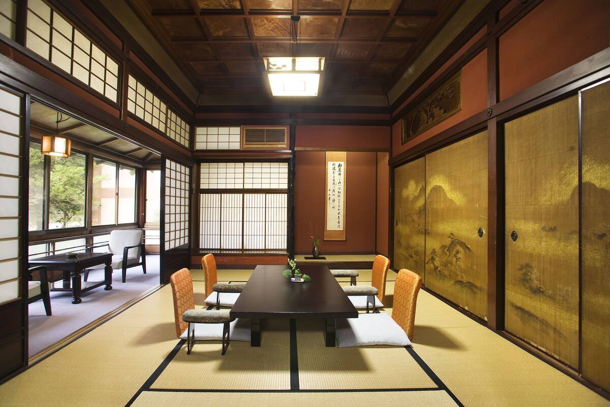 Une pièce de style japonais traditionnel, avec un sol recouvert de tatamis, une table basse et des paravents coulissants.