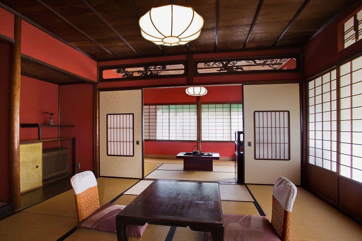 Une pièce de style japonais traditionnel, avec un sol recouvert de tatamis, une table basse et des paravents en papier de riz (shoji).