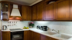 Une cuisine avec des meubles de rangement en bois, une cuisinière, un évier et une machine à café.