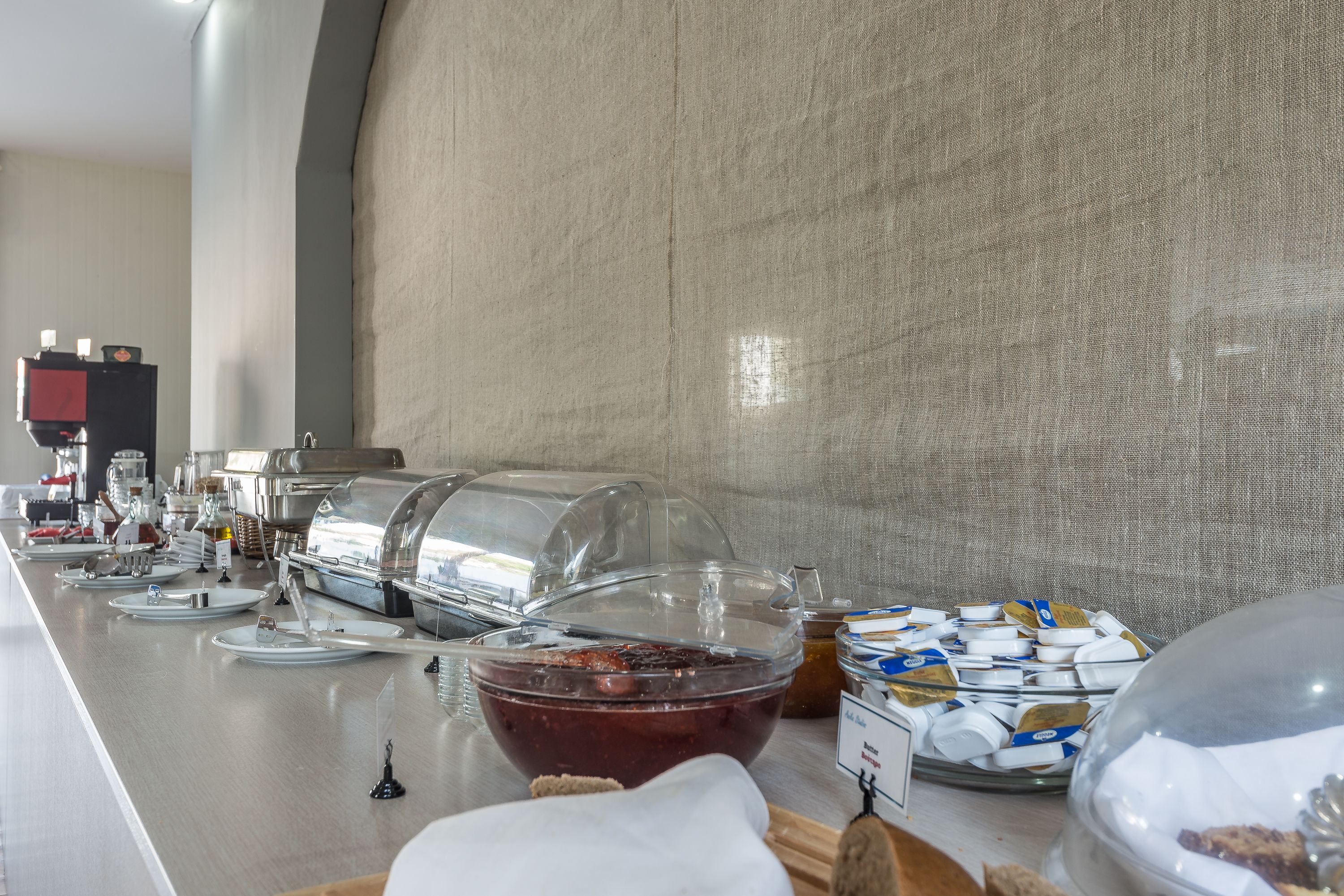 Een buffetopstelling met diverse soorten eten en een koffieapparaat.