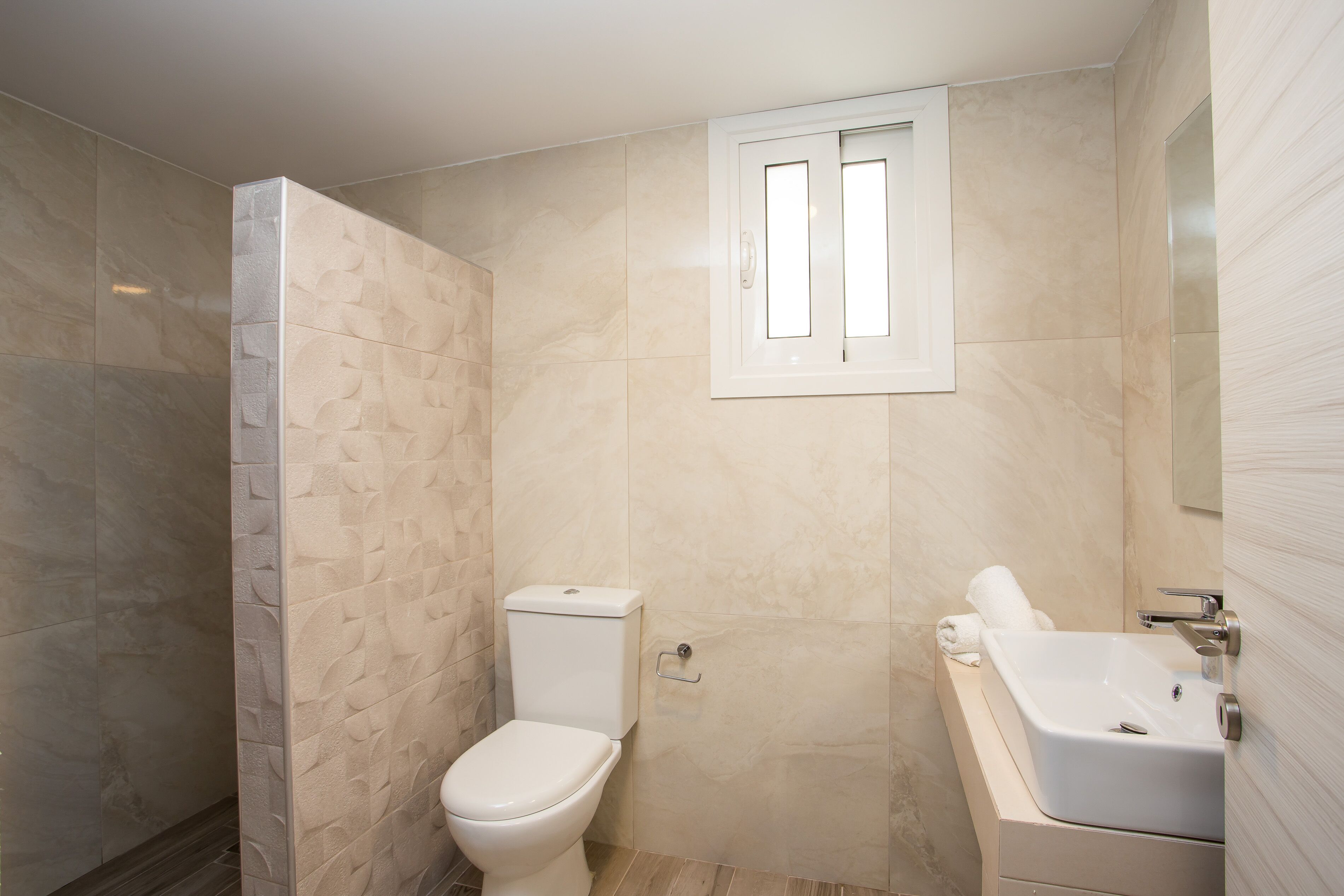 A bathroom with a toilet, a bathtub, and a shower area.