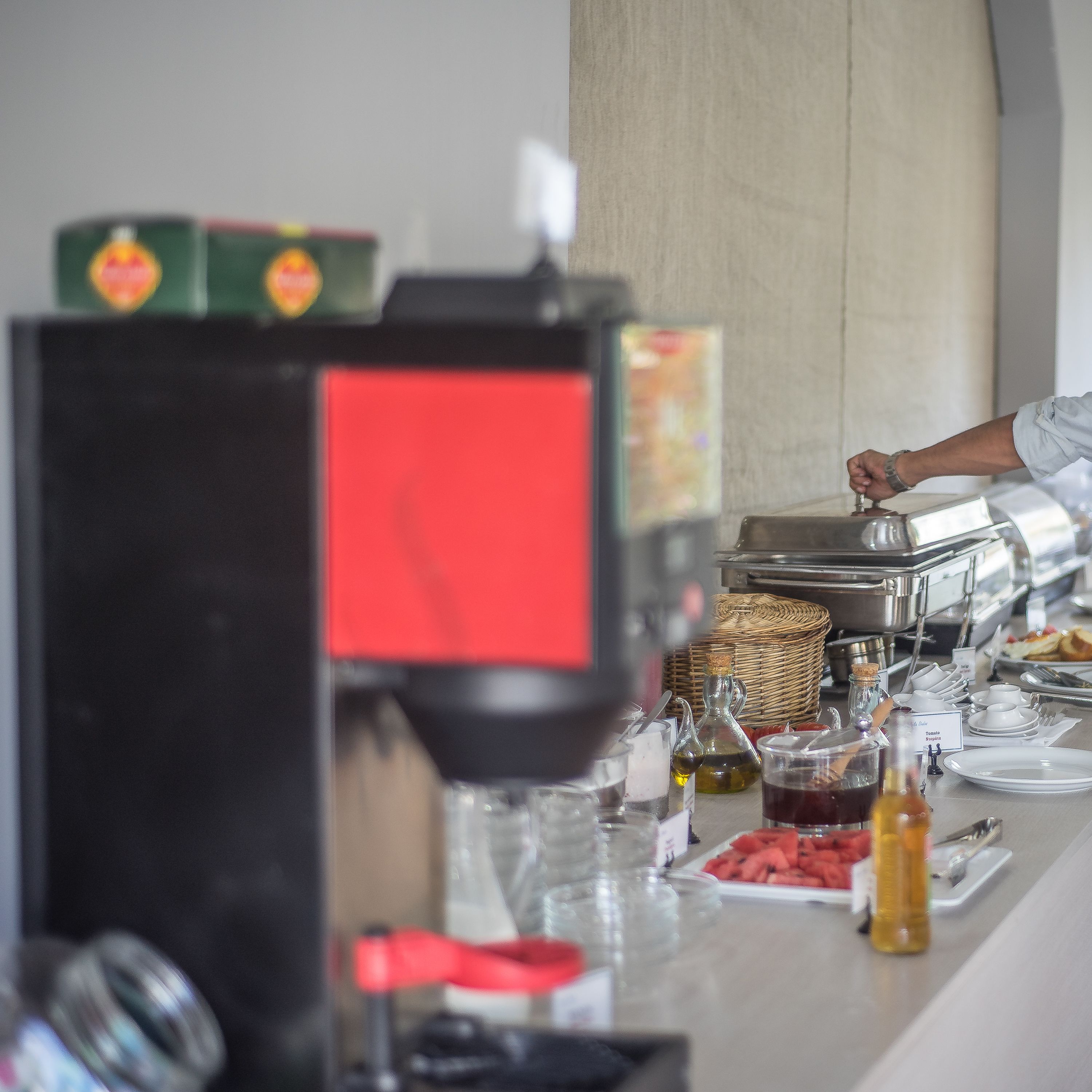 A buffet setup with various food items, condiments, and serving utensils.