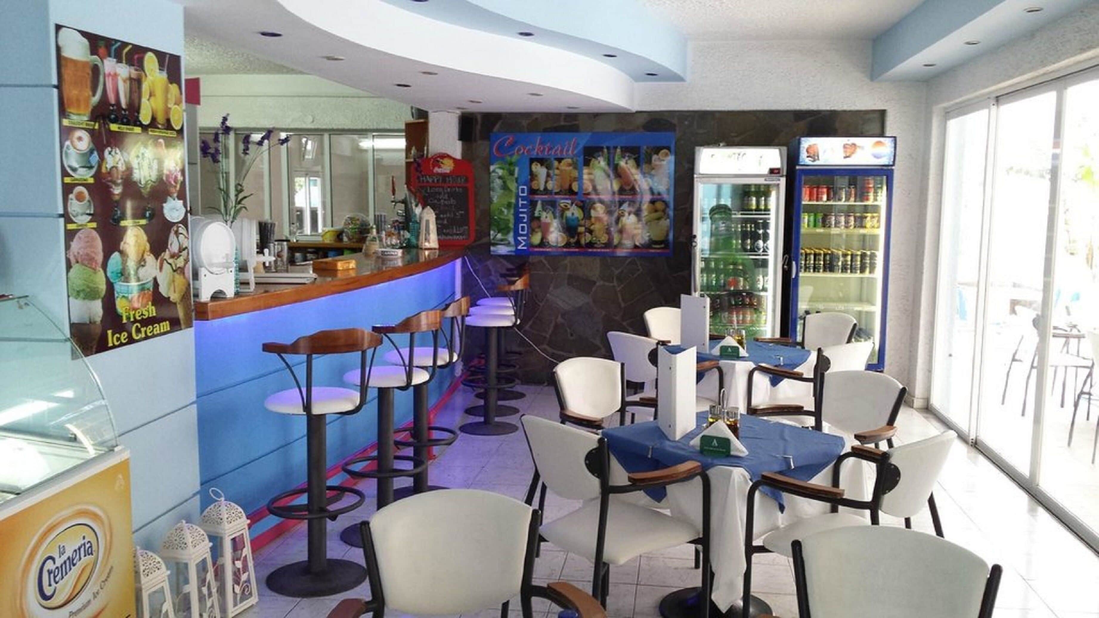 Un restaurant doté d’un bar, de plusieurs espaces pour s’asseoir et d’un présentoir de glaces.