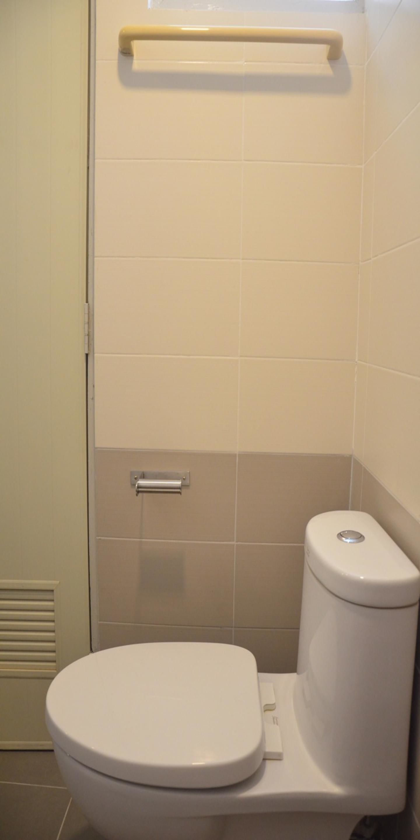 Un baño con inodoro, perchero y puerta.