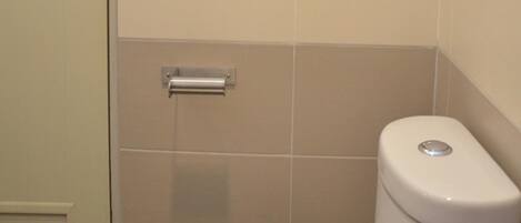 Un baño con inodoro, perchero y puerta.