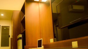 A modern kitchen with wooden cabinets and a built-in microwave. - LKP Apartment (Kanchanaburi)
