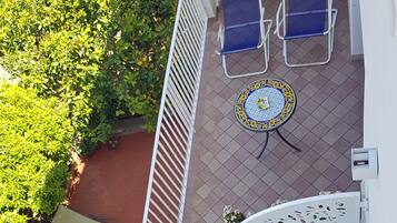 Une terrasse extérieure avec une table et des chaises, un mur décoratif et une rambarde.