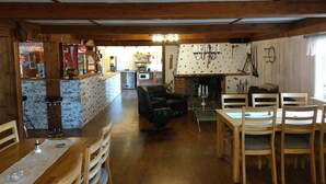 A cozy restaurant with a bar area, wooden furniture, and a fireplace. - Kvarngården Natur Resort (Byxelkrok)