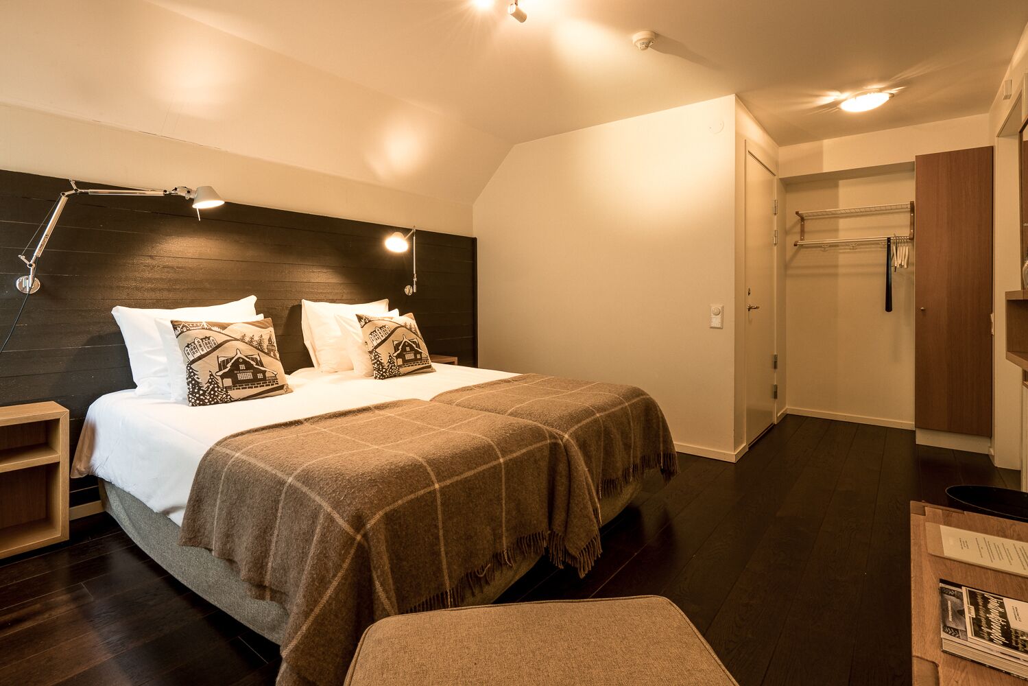 A bedroom with a bed, bedside tables, a desk, a wardrobe, and a closet.