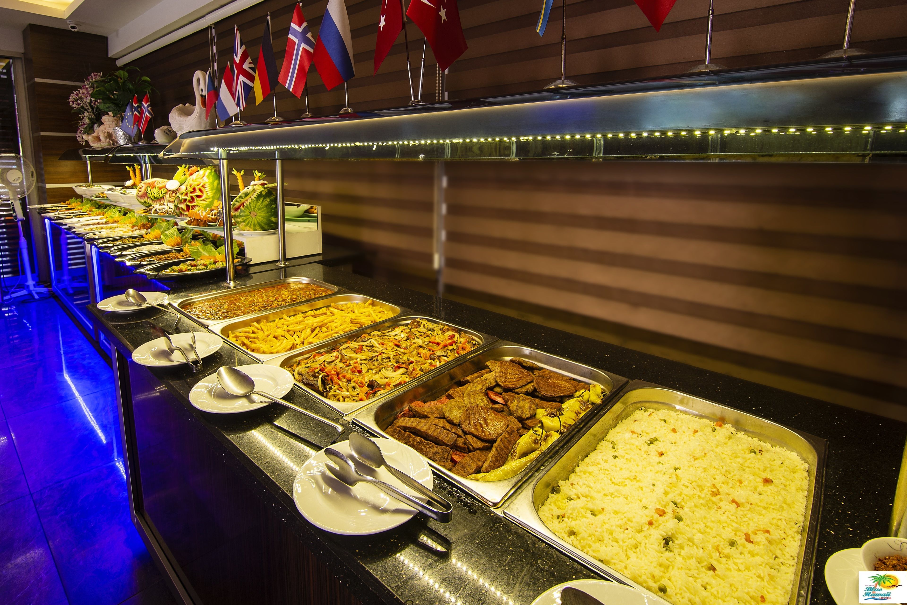 A buffet with various food options, including meats, rice, and vegetables.