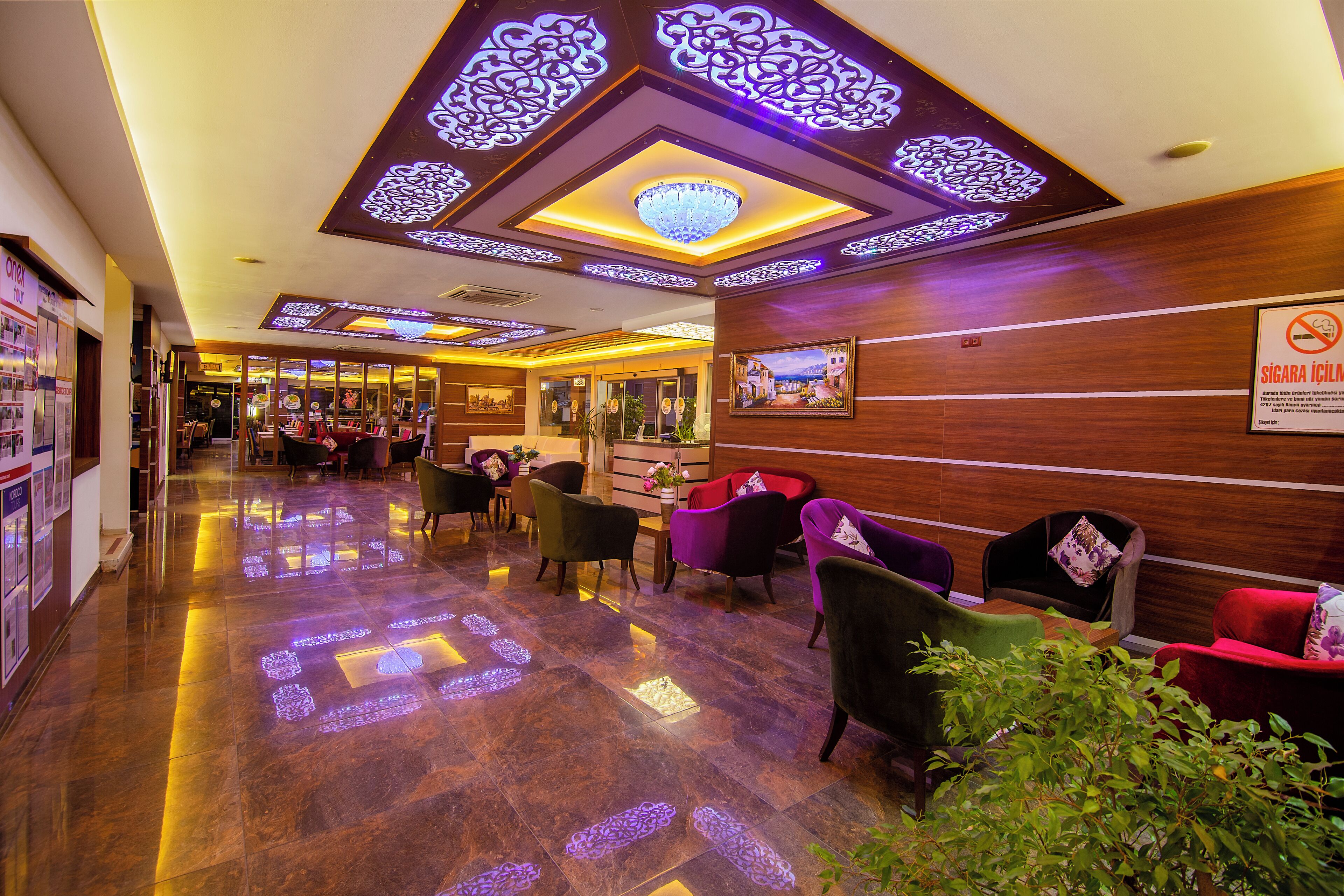 A hotel lobby with a reception desk, seating area, and a sign indicating a smoking area.