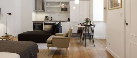 A modern apartment with a combined living and dining area, a kitchenette, and a separate bedroom.