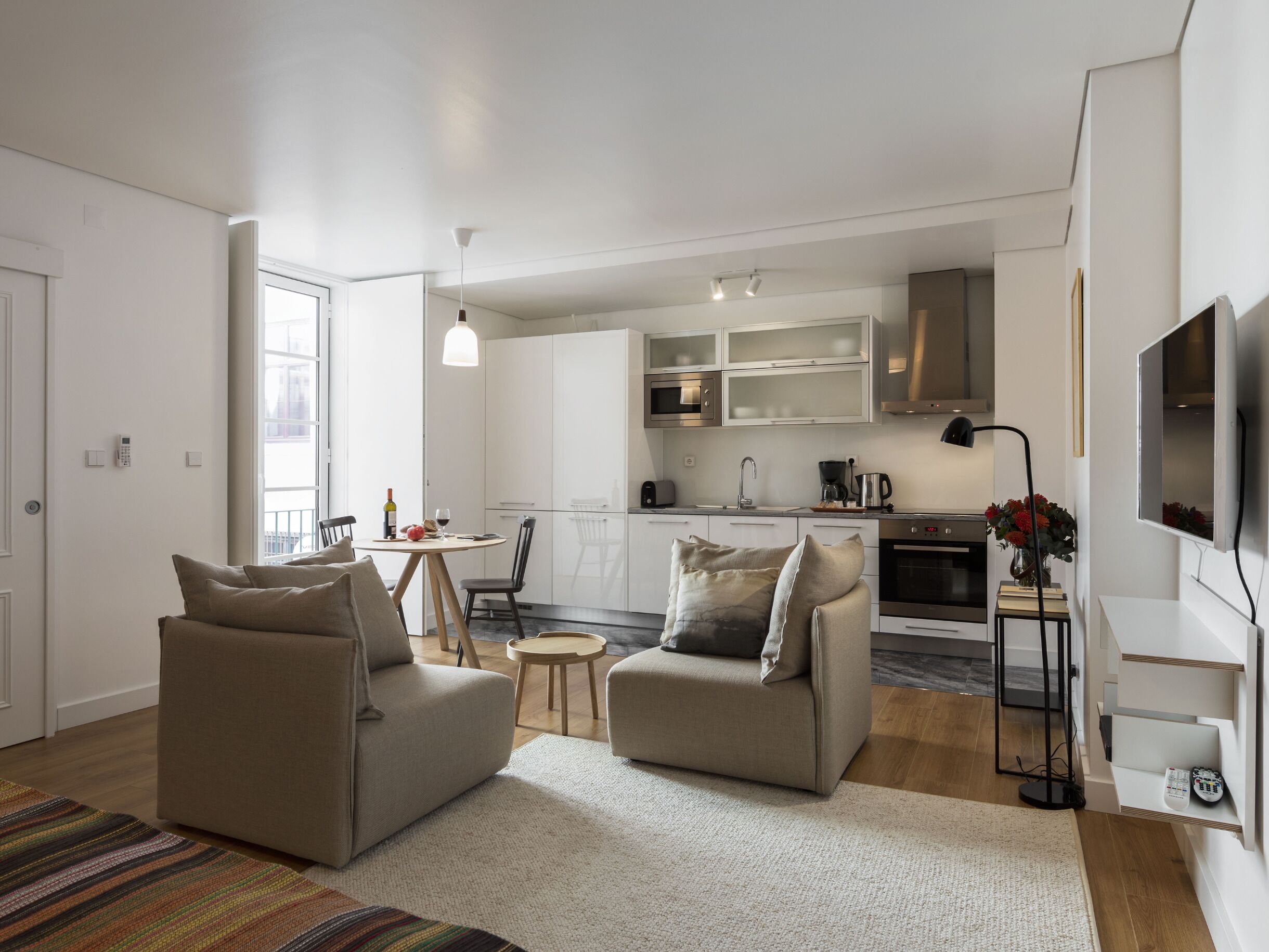 A modern apartment with a living room, kitchen, and dining area.