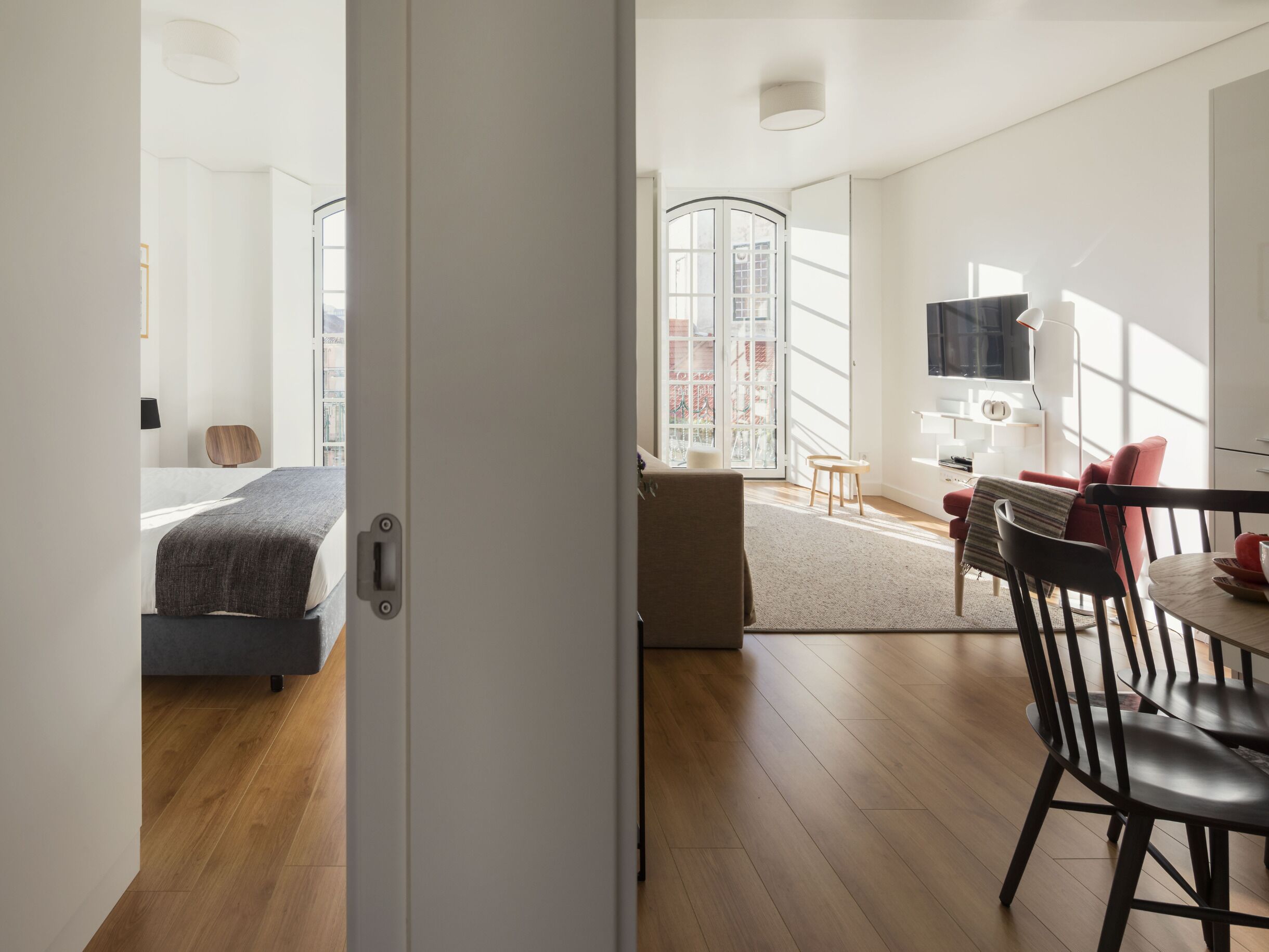 A modern hotel room with a bed, a desk, and a seating area.