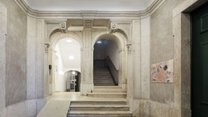 Eine prachtvolle Eingangshalle mit Marmorwänden, einer Treppe und einer Tür am Ende.