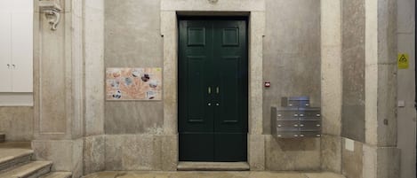 Una puerta verde con una placa y una caja de alarma contra incendios.
