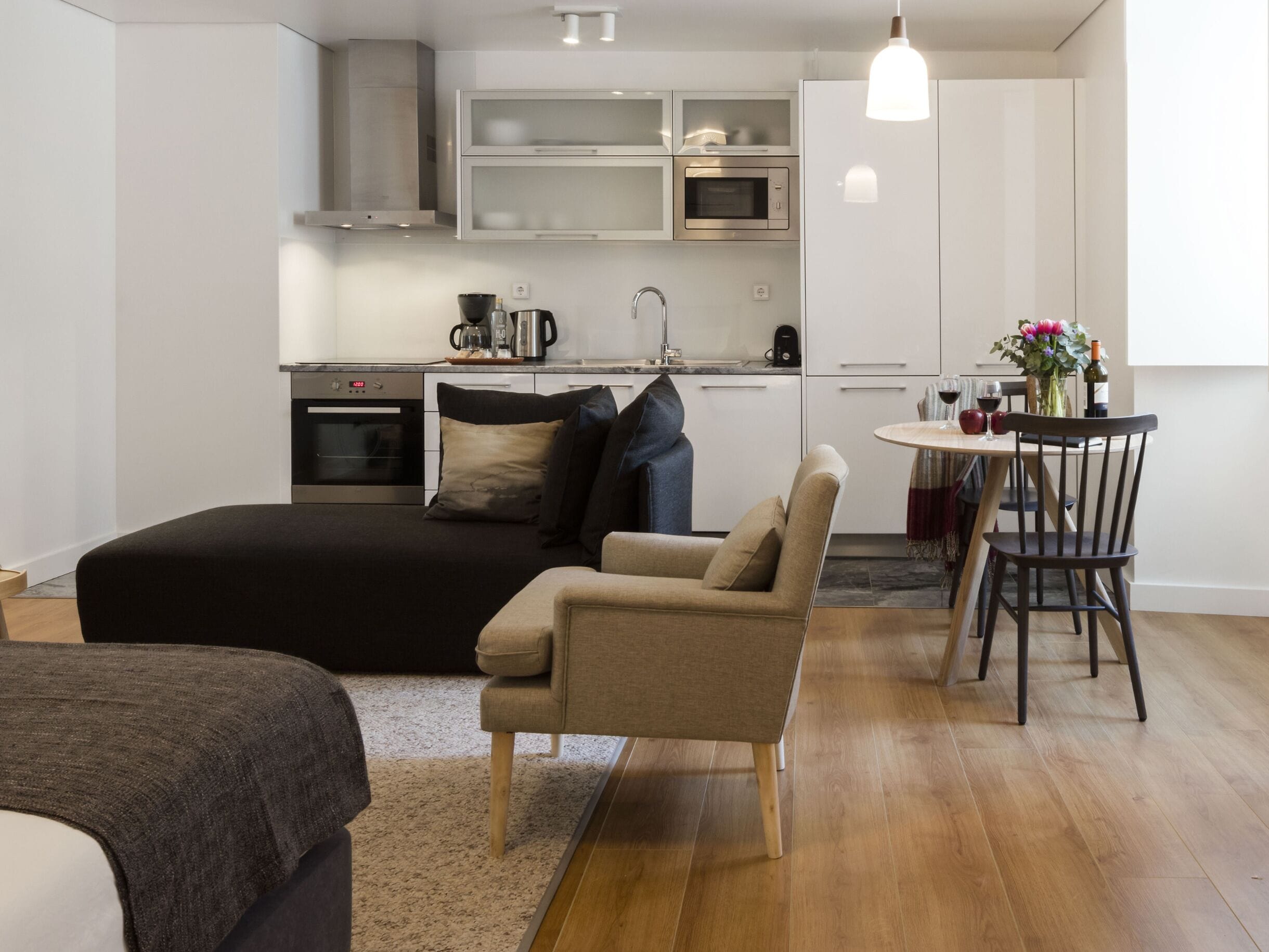 Un espace de vie moderne et compact, comprenant un coin cuisine, un espace repas et un coin salon confortable.