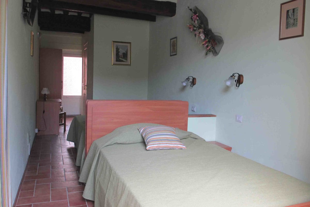 A bedroom with a single bed, a wooden headboard, and a small bedside table.