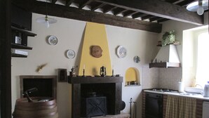 A kitchen with a built-in fireplace, a sink, and a dining area. - Bed & Breakfast Lucca Fora (Capannori)