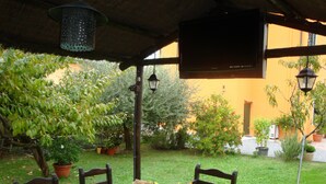 A covered outdoor dining area with a table, chairs, and potted plants. - Bed & Breakfast Lucca Fora (Capannori)