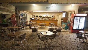 A restaurant with a bar area, tables, chairs, and a Coca-Cola refrigerator. - Stella View Studios (Rhodes)