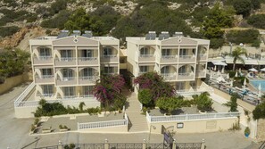 A multi-story hotel with balconies, solar panels, and a pool area. - Stella View Studios (Rhodes)