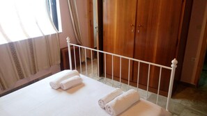 Une chambre à coucher avec un lit, des barreaux blancs et une armoire en bois.