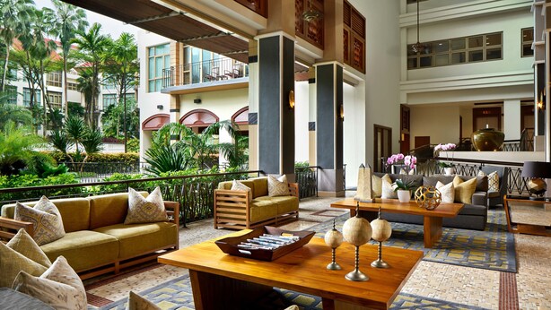 A spacious lobby with a high ceiling, multiple seating areas, and a view of the surrounding greenery. - Treetops Executive Residences (Singapore)