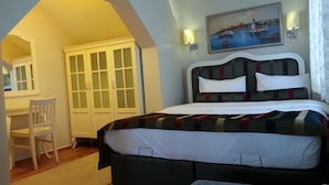 Un dormitorio con cama, una silla, un escritorio y un armario.