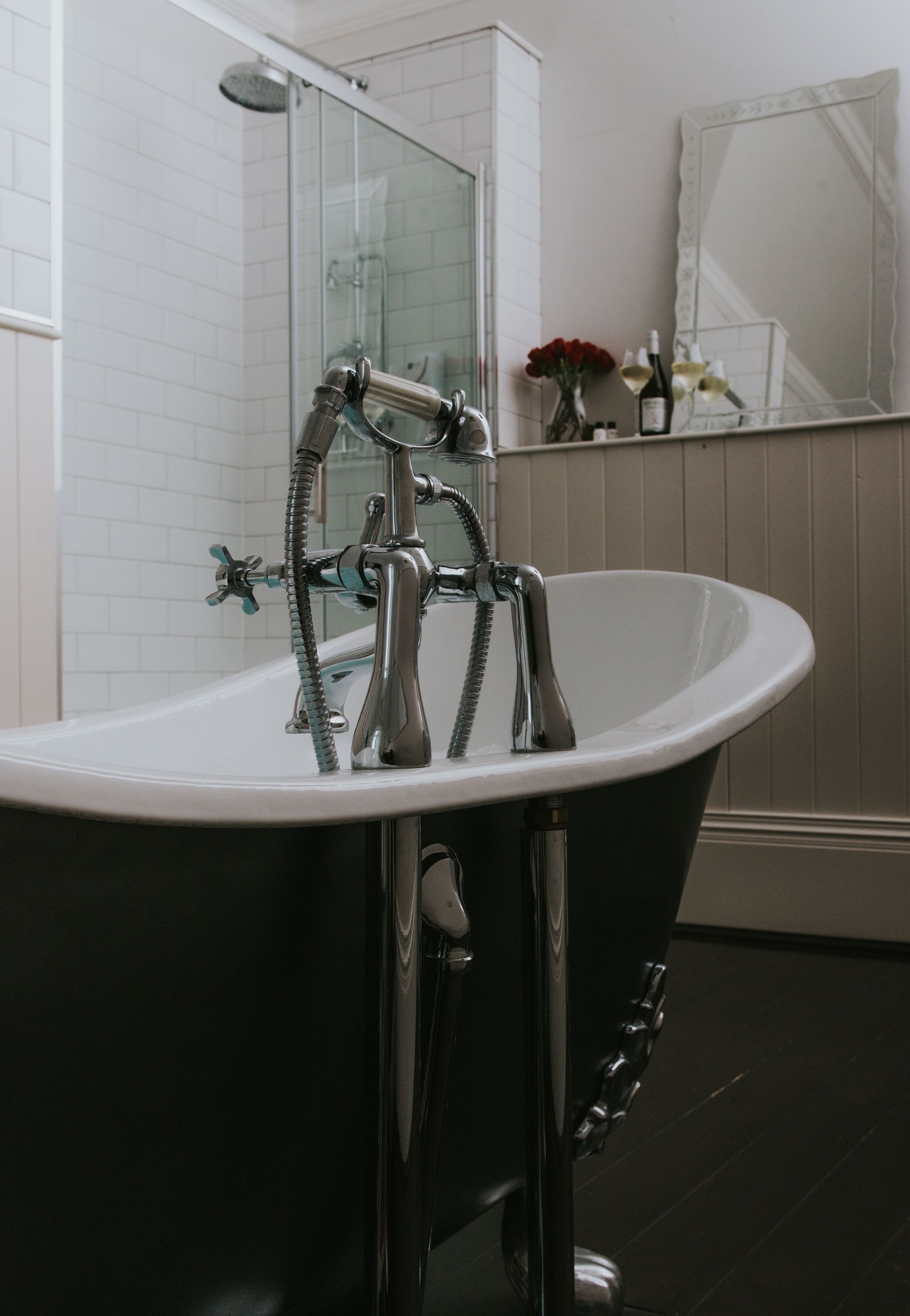 A modern bathroom with a freestanding bathtub, a glass shower enclosure, and a mirror above the sink.