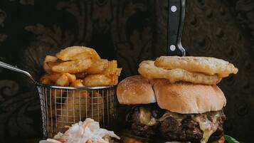 A burger with fries and coleslaw on a plate.