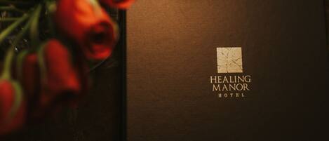 A brochure for Healing Manor Hotel with a logo featuring a cracked square.